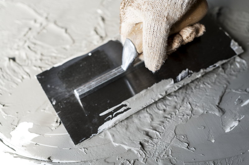 Construction worker applying mortar plaster on wall